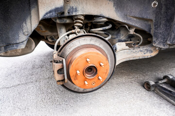 An old rusty car brake disc is lubricated with copper grease