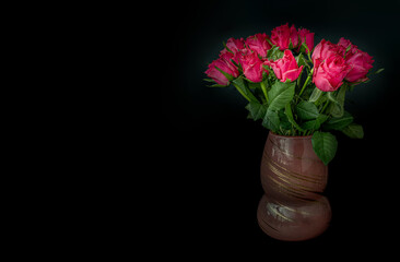 Pretty red-pink roses decorative in a Glass vase on Dark background for Valentine's Day. Symbol of Love, Space for text, Selective focus.