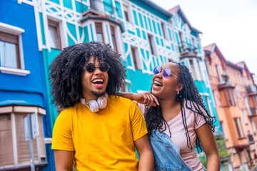 African friends with sunglasses and denim casual clothes laughing outdoors