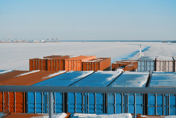 Container Ship Sailing Underway In The Frozen International Shipping Fairway Route. Water Surface Covered With Ice. Winter Navigation in The Arctic Area Region