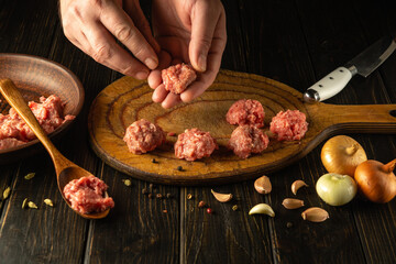 The chef hands form meatballs from ground beef. Concept of preparing a meat dish at brunch