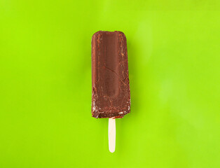 chocolate ice cream on a stick on a light green background