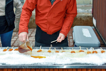 Man creates Maple taffy in the snow.