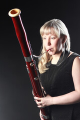 Bassoon woodwind instrument player. Classical musician woman playing orchestral bass.