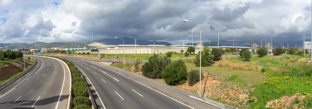 Panoramic View of a Curved Highway Leading into a Mountainous Region on a Cloudy Day