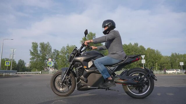 Caucasian man rides on an electric motorcycle. 