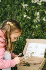 Scavenger hunt for kid in the park. Girl learning about environment. Natural education activity for...