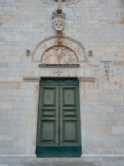 Fototapeta na wymiar Door of a church surmounted by a lunette depicting the Crucifixion