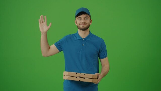 Green Screen Portrait of Handsome Food Delivery Person in Uniform Holds Holding Take Away Pizza Boxes and Coffee, Smiles. Employee Bringing Fast Food to Business Office.