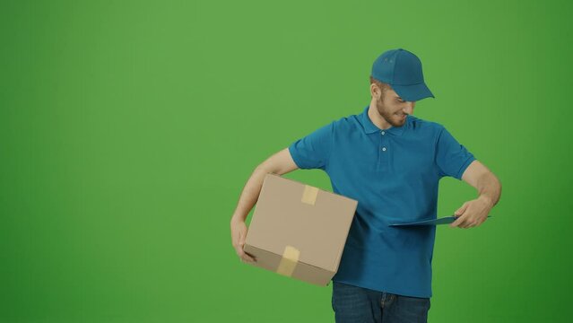 Green Screen Portrait of a Delivery Person in Uniform Holds Cardboard Boxes and Smiles. Courier Working in Logistics Distribution Center, Delivering Online Orders. Great delivery service.