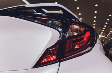 Close up of taillight detail of modern luxury sportscar with reflection on white paint after wash...