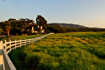 White Three Rail fence separating home from pasture 