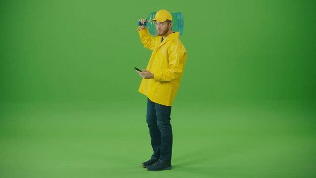 Green Screen Food Delivery Person in Yellow Uniform Brings on Shoulder a Big Bottle of Water while. Courier On the Way to Deliver Order to Client.
