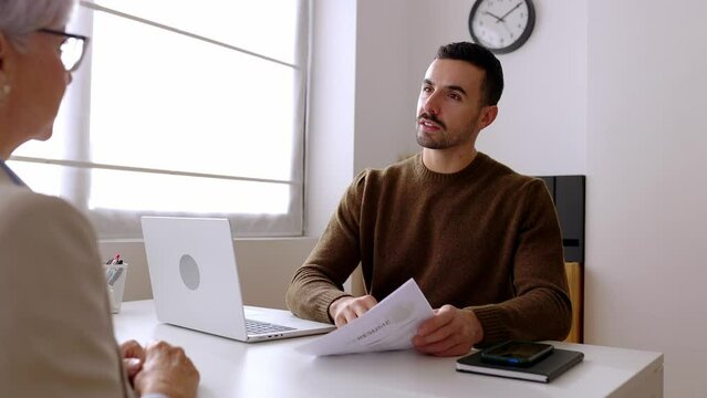 Male HR recruiter shaking hand with mature female applicant at meeting room. Professional Human Resources manager doing a job interview to senior woman candidate. Career and opportunities concept.