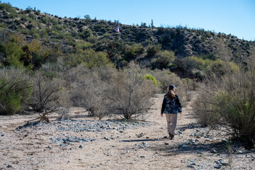 A woman hiking in Tonto National forest trail near and American flag