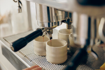 Coffee machine filling a two cups with espresso in professional coffee shop. High quality photo