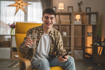 man young caucasian male teenager hold glass of water at home
