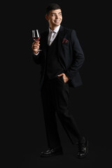Obraz premium Young sommelier with glass of pink wine on black background
