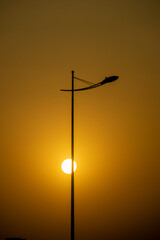 Fototapeta na wymiar Golden sun during sunset and lamp post
