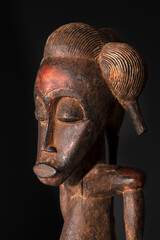 Fototapeta na wymiar Close-up of a wooden Senufo Male figure from Ivory Coast with a brown patina isolated on black. Tribal African art, showcasing masterful craftsmanship and spiritual symbolism.