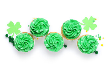 Tasty green cupcakes with decor for St. Patrick's Day on white background