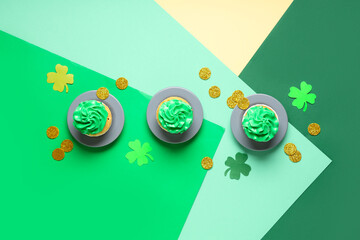 Plates with tasty cupcakes and decor for St. Patrick's Day on color background