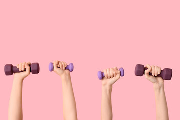 Female hands with different dumbbells on pink background, closeup