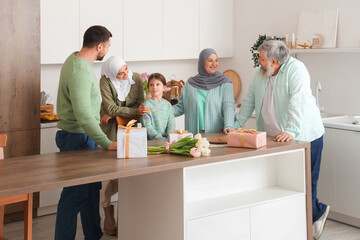 Happy Muslim family with gifts in kitchen. Ramadan celebration