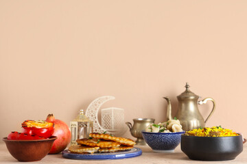 Traditional Eastern dishes and Muslim decor on beige background. Ramadan celebration