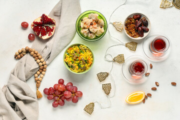 Traditional Eastern dishes, prayer beads and Muslim decor on white table. Ramadan celebration