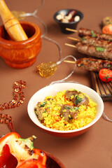 Traditional Eastern dishes, prayer beads and Muslim decor on brown background. Ramadan celebration