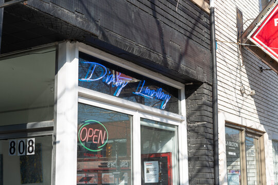 neon blue sign above entrance to Dirty Laundry, a laundromat, located at 808 Dundas Street West in Toronto, Canada