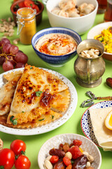 Traditional Eastern dishes on green background, closeup. Ramadan celebration