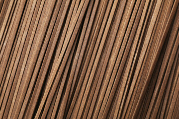 Uncooked buckwheat noodles (soba) as background, top view