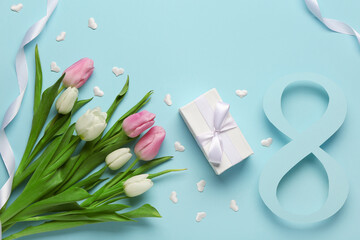 Figure 8 made of paper with tulip flowers and gift box on blue background. International Women's Day celebration
