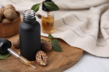 Nutmeg essential oil and nuts on table. Space for text