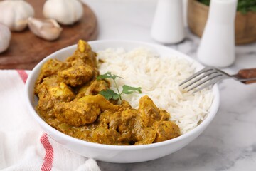Delicious chicken curry with rice on white marble table, closeup