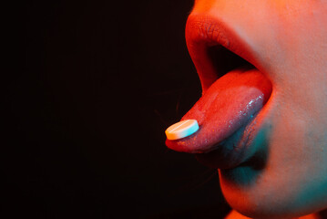 Pills for sex. Woman taking pills, closeup. Take medicine. Female tongue with tablet pills. Cropped...