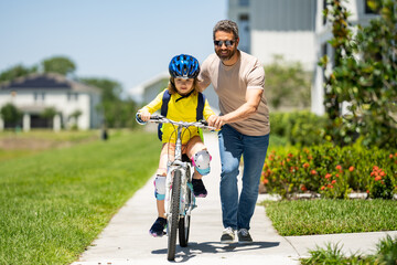 Fathers day. Father and son riding a bike on the road at the fathers day. Concept of friendly...