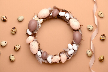 Easter wreath made of eggs and feathers on beige background