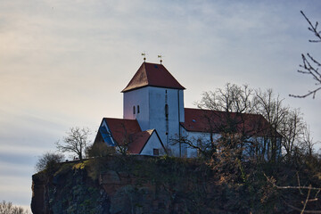 Fototapeta premium Weitwinkel-Panorama der Bergkirche Beucha auf dem markanten Porphyrfelsen mit perfekter Spiegelung im ruhigen Steinbruchsee, Brandis, Sachsen, Deutschland