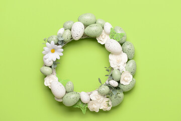 Easter wreath with white flowers, eggs and butterflies on bright green background © Pixel-Shot