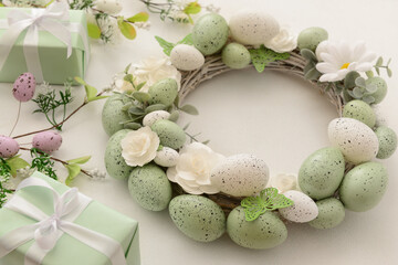 Easter wreath with white flowers, eggs and butterflies on light background