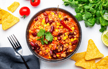 Chili con carne, mexican dish with minced beef, red beans, paprika, corn and hot peppers in spicy tomato sauce, tex-mex cuisine, white background, top view