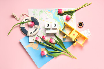 Composition with world maps, toy plane, ticket and flowers for International Women's Day on pink...