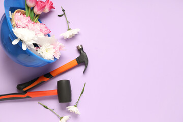 Composition with constructor's tools and spring flowers on color background. International Women's...