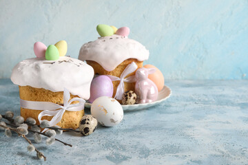 Composition with delicious decorated Easter cakes, porcelain bunny and painted eggs in plate on...