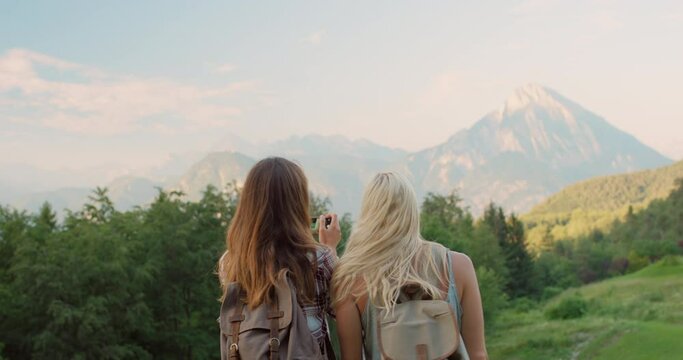 Women, friends and cellphone or photography of mountain for travel or social media post, adventure or Europe. Female people, selfie and hiking in nature for summer backpack journey, trekking or back