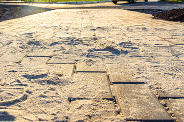 transport of sand by wind or water causes footpaths and paving slabs to be covered with a thick layer of sand, selective focus