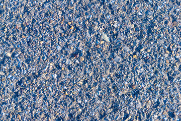 texture of old asphalt pavement illuminated by low evening sun, selective focus